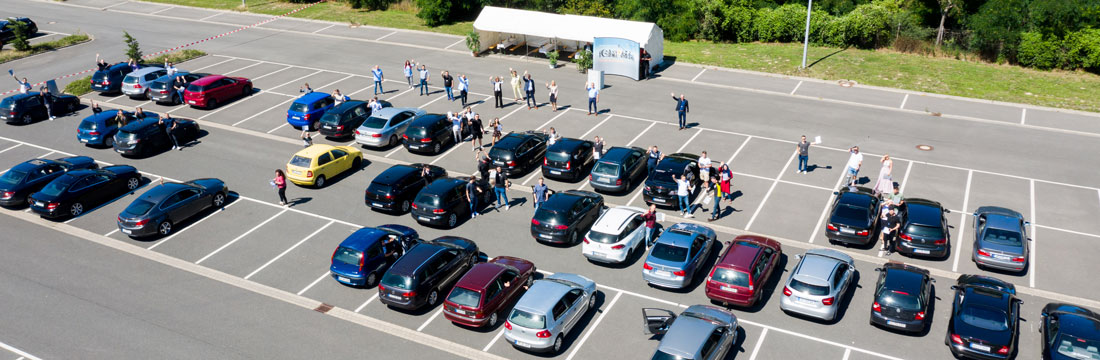 Foto des Parkplatzes mit den winkenden Auszubildenden von oben fotografiert